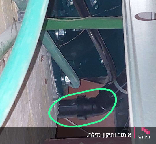 צינור שחור עם חיבורי מתכת בקיר